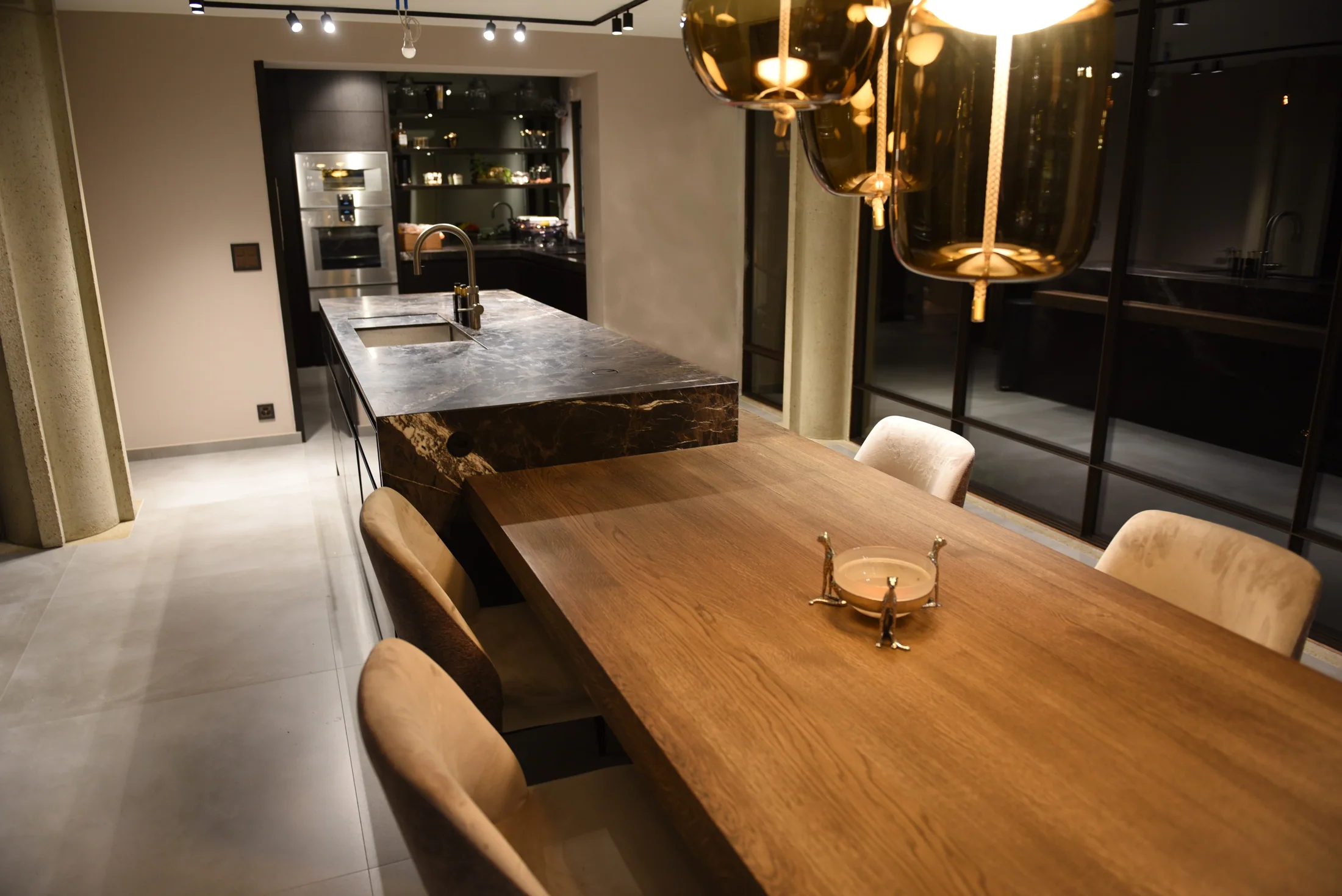 Houten tafel die aansluit op het marmeren eiland