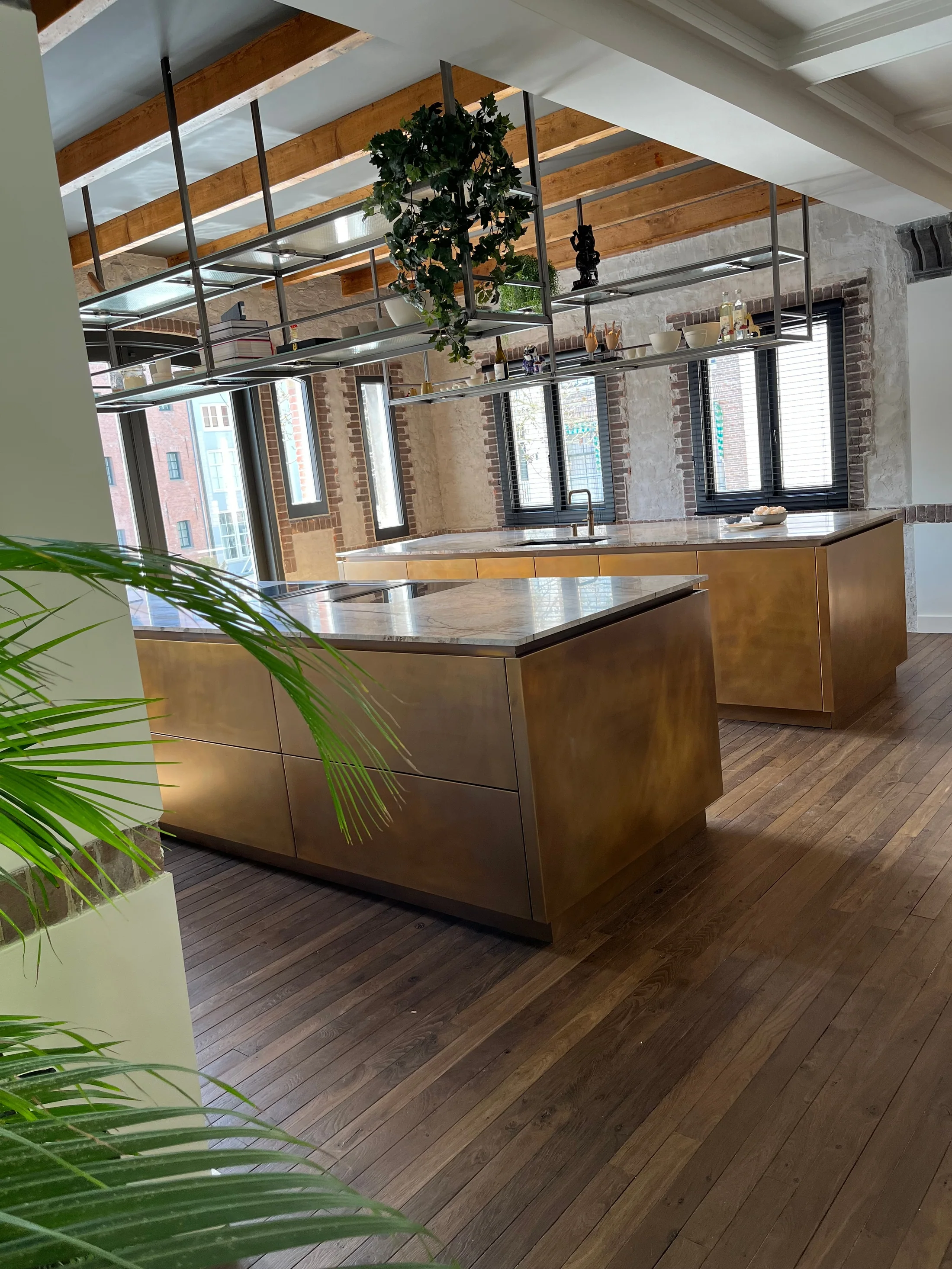 Twee messing eilanden onder houten balken en een open hangrek
