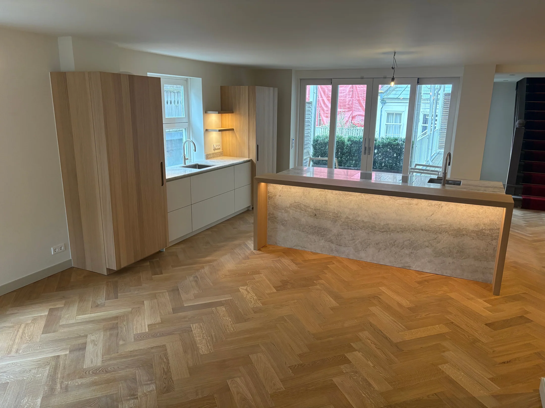 Eiken keuken met een verlicht natuurstenen front aan het eiland