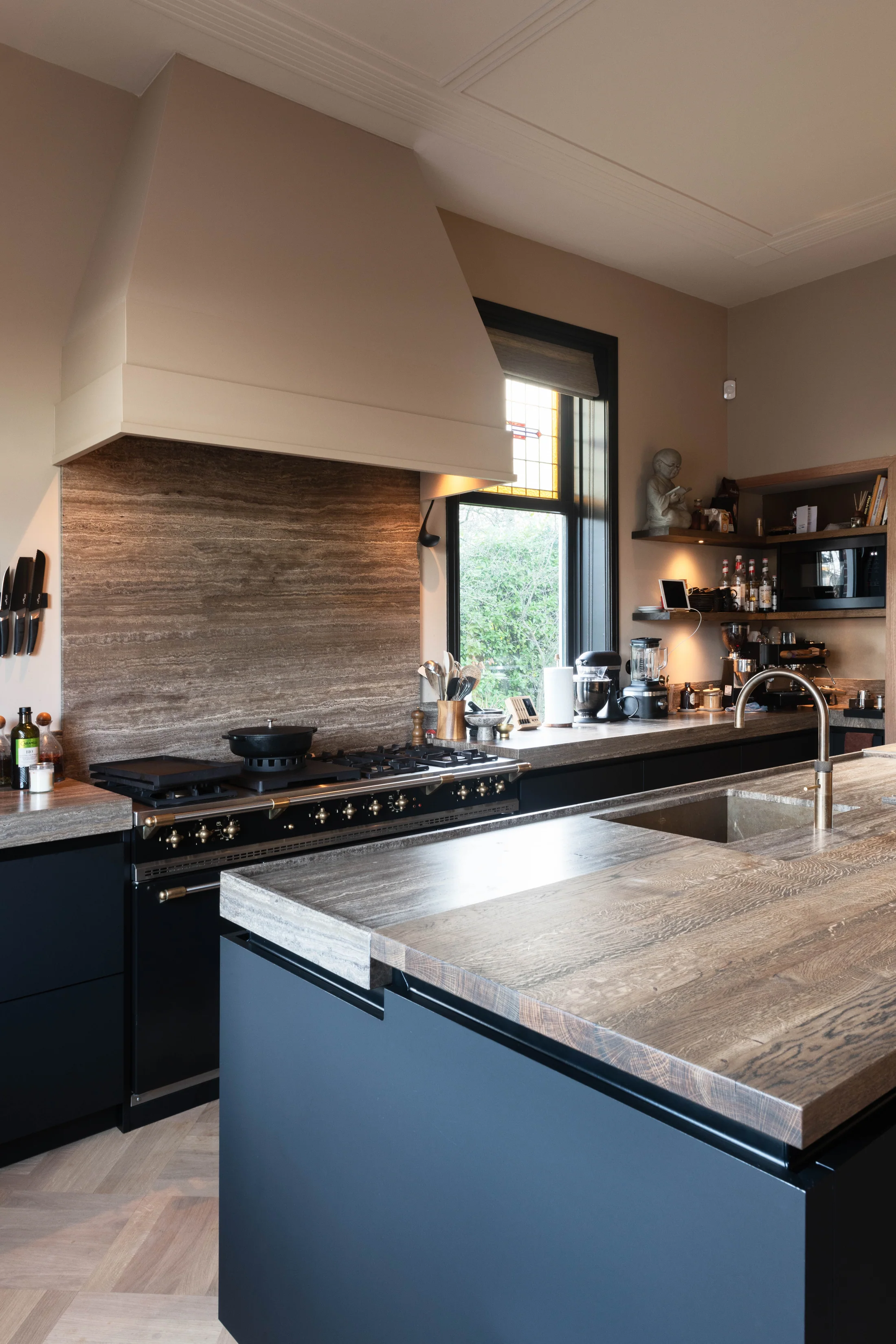 Donkere keuken met eiland, houten blad en hoge ramen