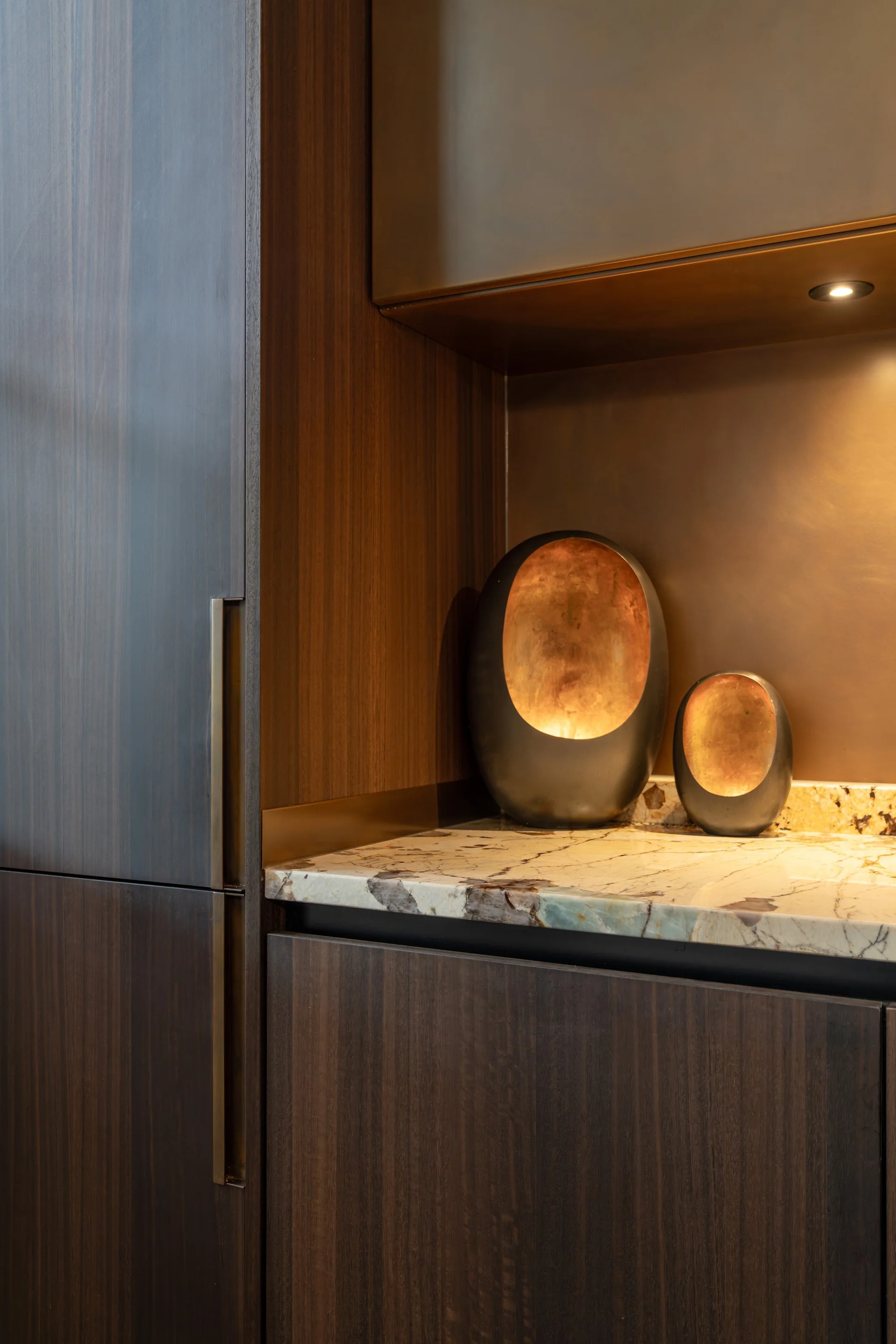 Messing nis en donker hout naast het natuurstenen werkblad