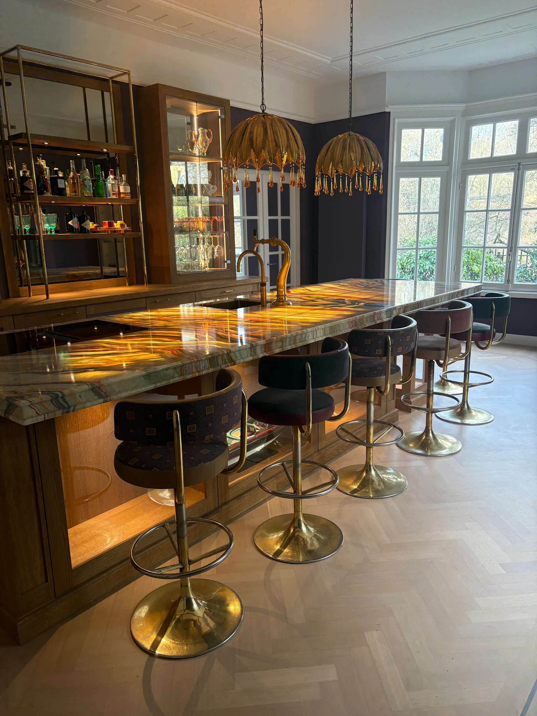 Verlicht onyx eiland met zitplaatsen voor een eiken kastenwand